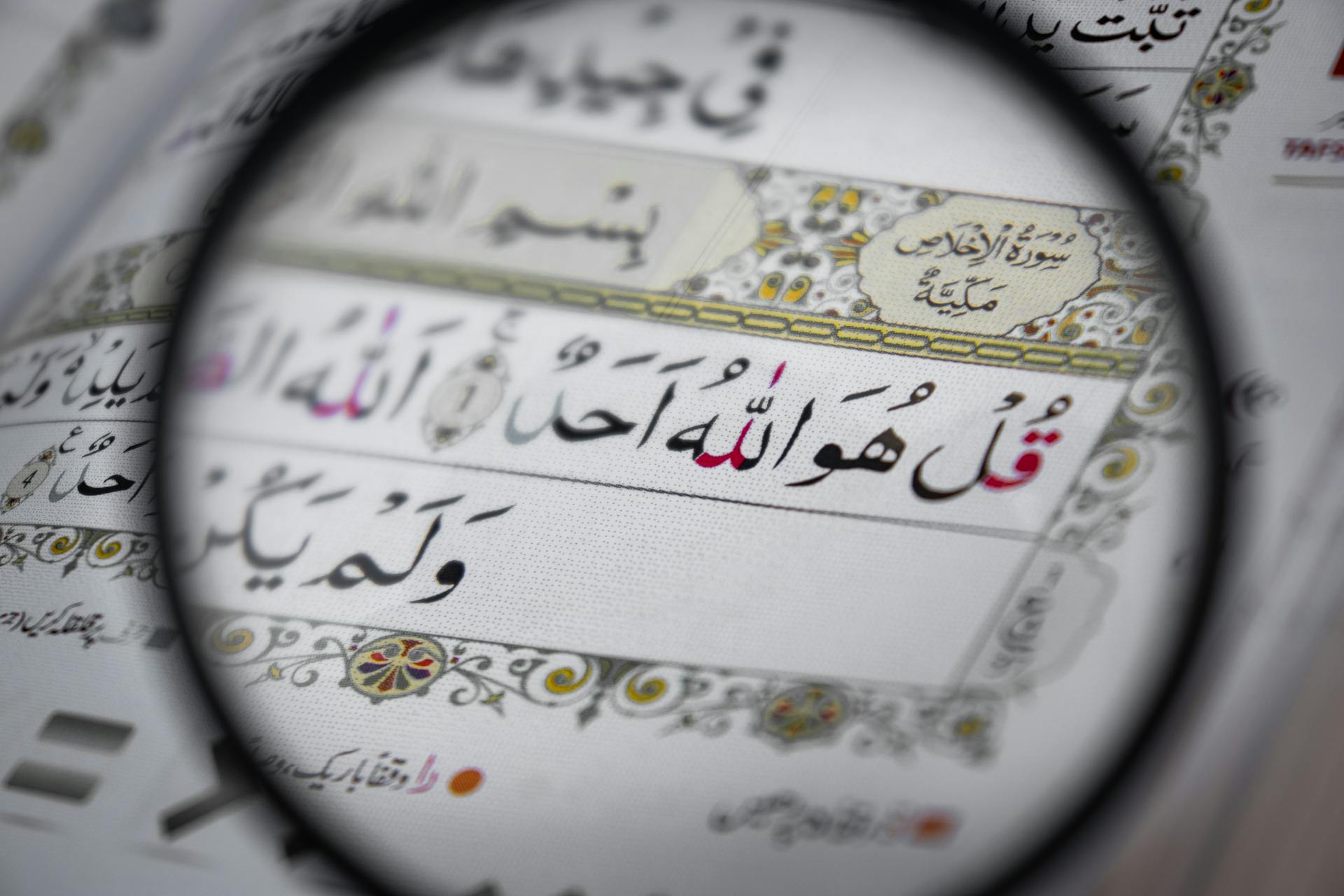 آية قرآنية مكبّرة بعدسة، تعبّر عن التأمل العميق وتدبر كلام الله